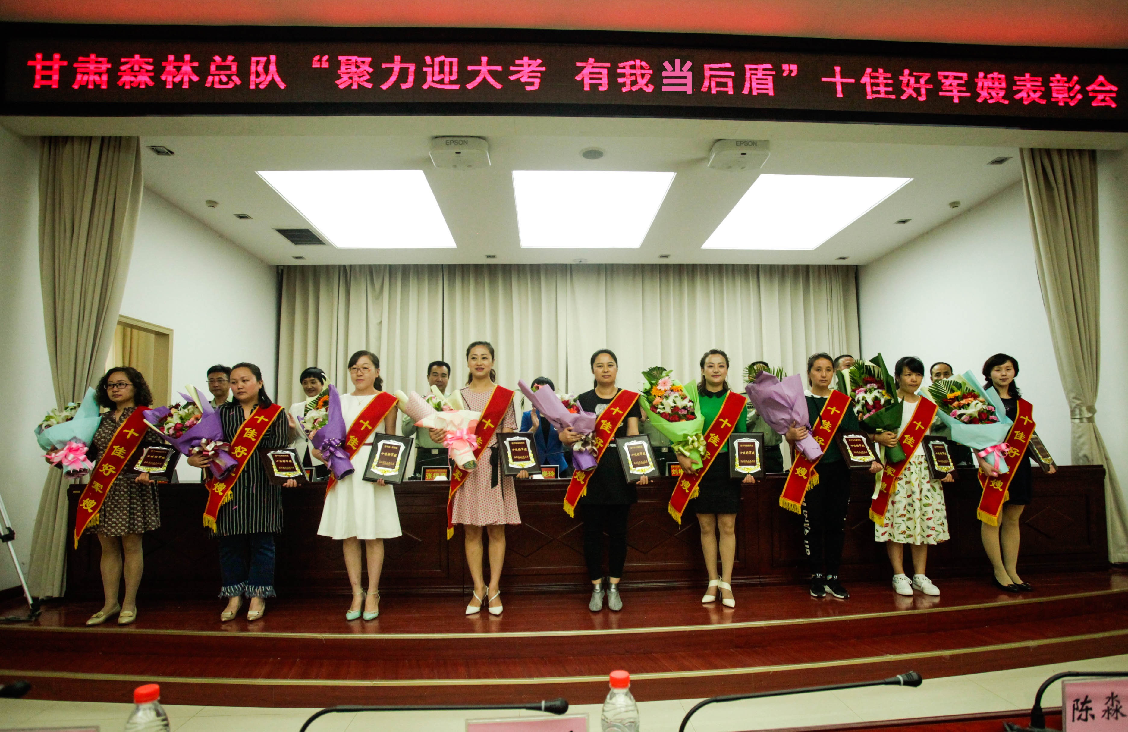 图1：受表彰的10名好军嫂只有9名来到了大会现场，该总队直工科长常利的爱人孙毓英远在安徽怀远一所中学任教，她带的学生们即将高考了，为了不影响孩子们，孙毓英最终遗憾缺席。.jpg
